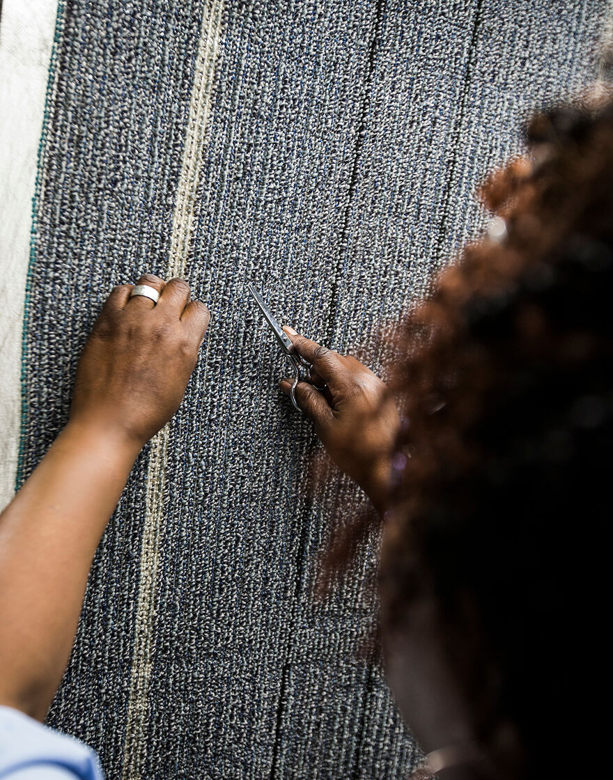 FLOR employee working closely on FLOR area rug material
